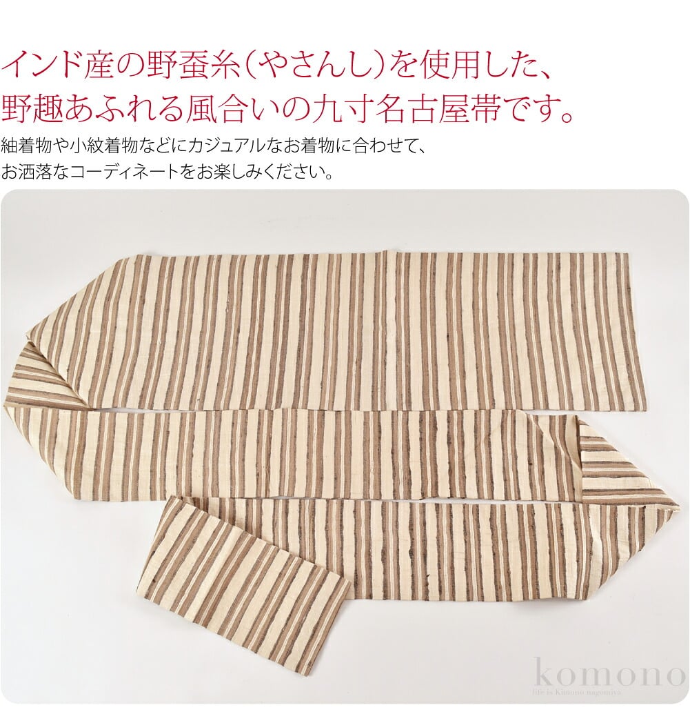 野蚕糸のインドシルク九寸名古屋帯です。インド産の野蚕糸（やさんし）を使用した、野趣あふれる風合いの名古屋帯です。野蚕糸とは、自然に生息する蚕の繭から紡がれた紬糸です。繭ごとに生成り、茶色など発色が様々で、繊維も太いのが特徴です。