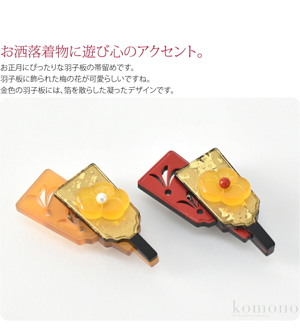 お洒落着物に遊び心のアクセント。お正月にぴったりな羽子板の帯留めです。羽子板に飾られた梅の花が可愛らしいですね。金色の羽子板には、箔を散らしています。色の異なる樹脂を切り絵風に重ねた、凝ったデザインです。