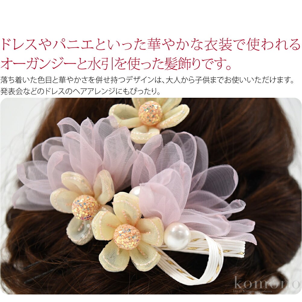 ドレスやパニエといった華やかな衣装で使われるオーガンジーと水引を使った髪飾りです。オーガンジーは、薄手で程良いハリ感を持ち合わせ、上品な透け感が透明感を演出し、独特の弾力性が特徴です。中心にラメをあしらったお花が華やかさをプラスしています。