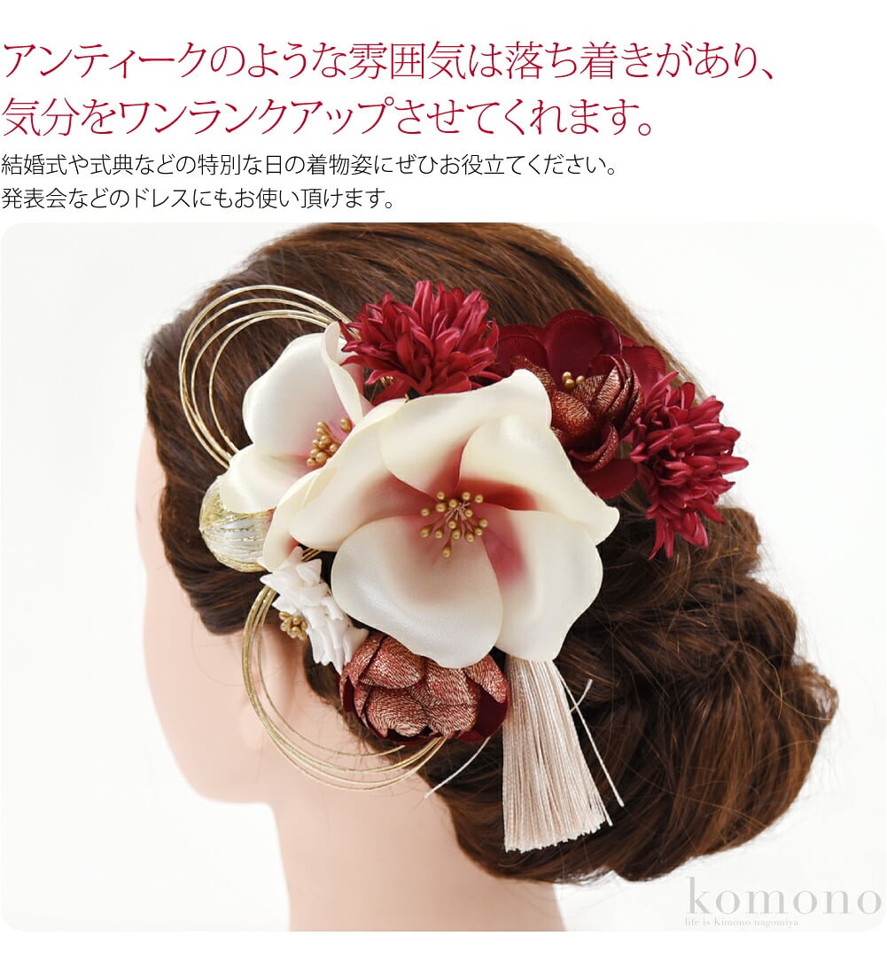 ニュアンスカラーの花にところどころゴールドをあしらったゴージャスな髪飾りです。アンティークのような雰囲気は落ち着きがあり、気分をワンランクアップさせてくれます。和玉と水引がさりげない和のアクセント。光沢感のあるタッセルがお顔周りを一層華やかにしてくれます。