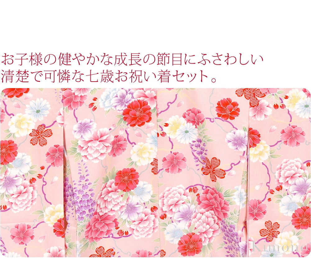 お子様の健やかな成長の節目にふさわしい清楚で可憐な七歳お祝い着セット。雪輪に大輪の牡丹、桜、藤の華やかな意匠に、絞り風模様の桜が可愛らしさを添えています。繰り返し模様の華やかな小紋柄です。お顔を明るく引き立る鮮やかな赤地の重ね衿つきです。